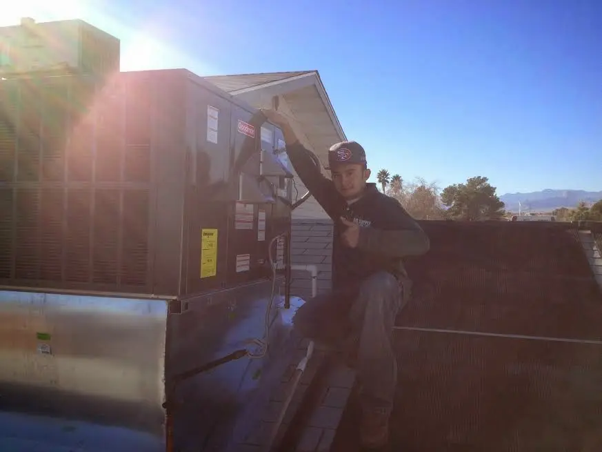HVAC technician performing HVAC Inspection on a rooftop unit in Palmyra