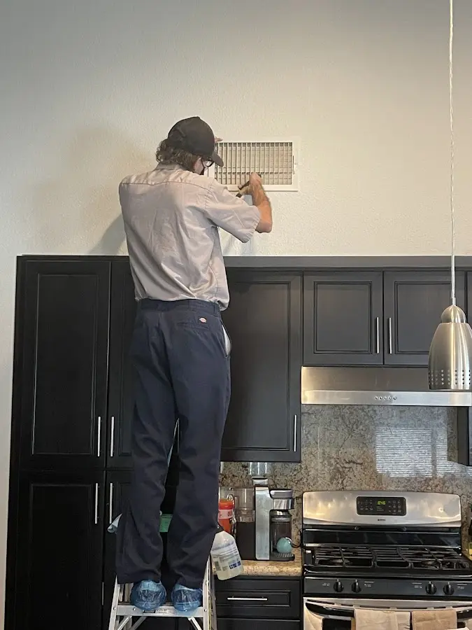 Technician inspecting an air vent during HVAC service in Palmyra